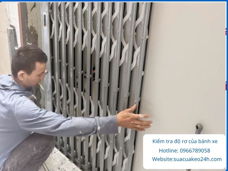 Thợ kỹ thuật kiểm tra độ rơ và độ rơ lắc của bạc đạn cửa kéo