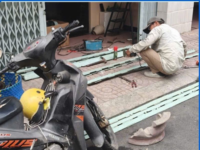 Thợ tháo lắp và xỏ xâu lại lá cửa kéo bị tuột ngàm tại công trình