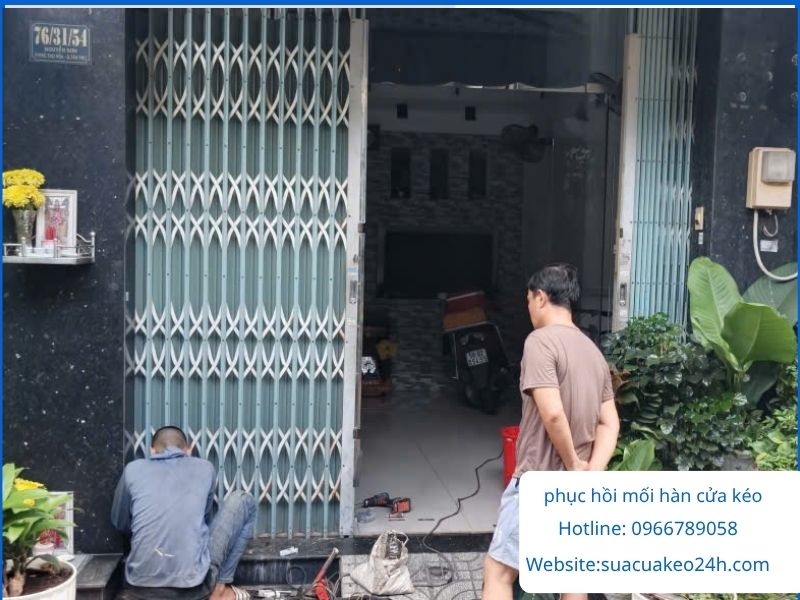 Thợ cơ khí thi công phục hồi mối hàn chân cửa kéo sắt bị nứt hở